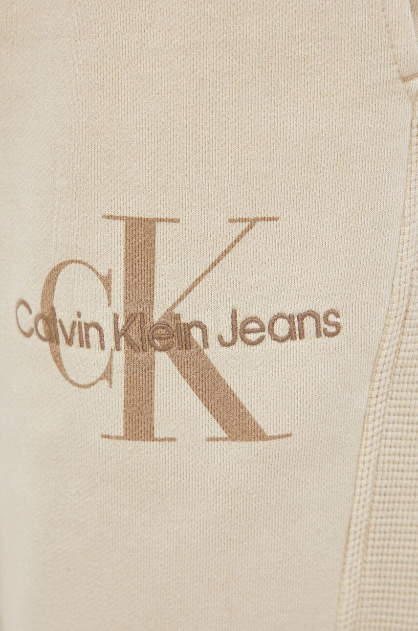 Calvin Klein Jeans Bavlněné tepláky béžová barva - Pepit.cz