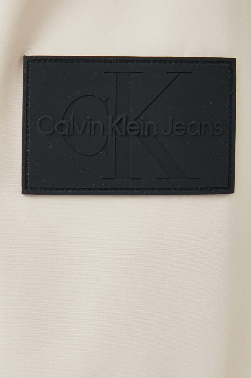 Calvin Klein Jeans Bunda pánská béžová barva přechodná oversize - Pepit.cz